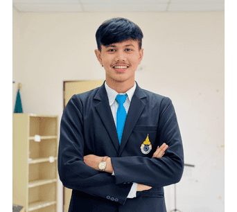 ภาพของนักศึกษาชายในชุดทางการของสถาบันอิสลามและอาหรับศึกษา มนร. ยืนในห้องเรียนพร้อมรอยยิ้มแสดงความมั่นใจและความภาคภูมิใจในสถาบัน.