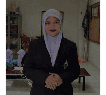 หญิงสาวในชุดนักเรียนอิสลามและผ้าคลุมหัวในห้องเรียน.